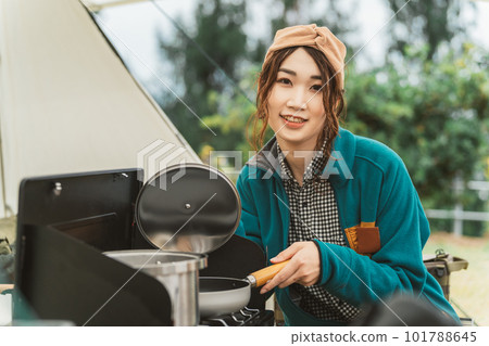 A woman who cooks at an outdoor campsite in autumn and winter (camping girl, Asian) 101788645