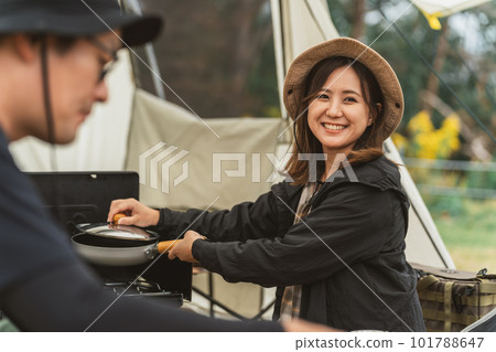 A woman and a man who cook at an outdoor campsite in autumn and winter (couple Asian) 101788647