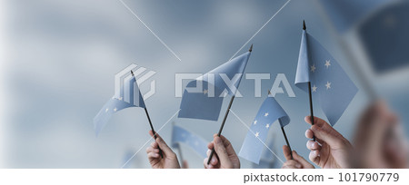 A group of people holding small flags of the Federated States Micronesia in their hands 101790779