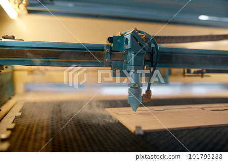 Closeup automated CNC laser machine operating with wooden plank 101793288
