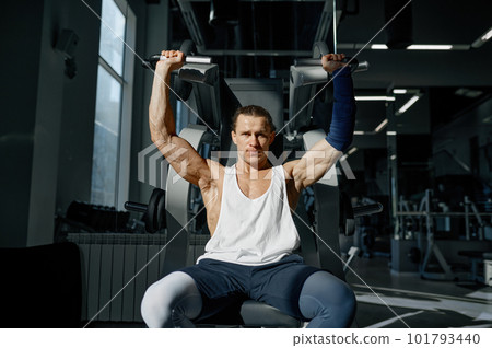 Serious exhausted man weightlifter working out with barbell 101793440