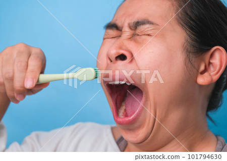 Yawn woman wake up with tooth brush on blue background. Oral care concept. Yawn woman wake up with tooth brush on blue background. Oral care concept. 101794630