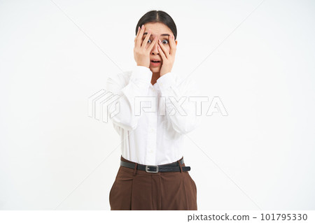 Image of young asian woman with terrified face, hides eyes behind hands and peeks through fingers with scared emotion, white background Image of young asian woman with terrified face, hides eyes behind hands and peeks through fingers with scared emotion, white background 101795330