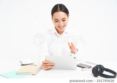 Portrait of successful female employee, asian woman talks via digital tablet on video chat, has online meeting with client while sits in her office, white background Portrait of successful female employee, asian woman talks via digital tablet on video chat, has online meeting with client while sits in her office, white background 101795626