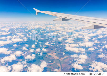 View from the airplane window at a beautiful cloudy sky and the airplane wing 101795835