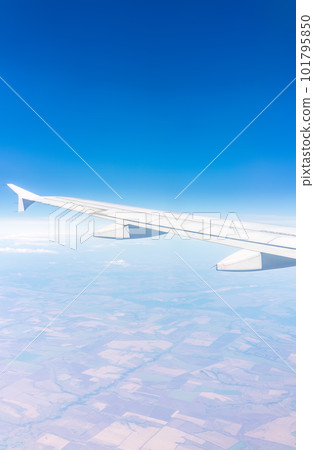 Aerial view from airplane window above green ground. View from the airplane window with beautiful clouds at sunrise Aerial view from airplane window above green ground. View from the airplane window with beautiful clouds at sunrise 101795850