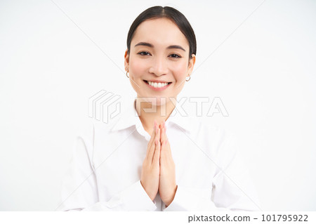 Namaste. Smiling japanese woman shows hands in pray, says thank you, bows politely, stands over white background Namaste. Smiling japanese woman shows hands in pray, says thank you, bows politely, stands over white background 101795922