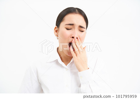 Tired businesswoman, korean entrepreneur yawns, feels tired, covers opened mouth with hand, stands isolated on white background Tired businesswoman, korean entrepreneur yawns, feels tired, covers opened mouth with hand, stands isolated on white background 101795959