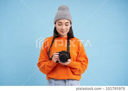 Passionate asian girl photographer, taking pictures on her digital camera, capturing moments outdoors, shooting photos, blue background Passionate asian girl photographer, taking pictures on her digital camera, capturing moments outdoors, shooting photos, blue background 101795978