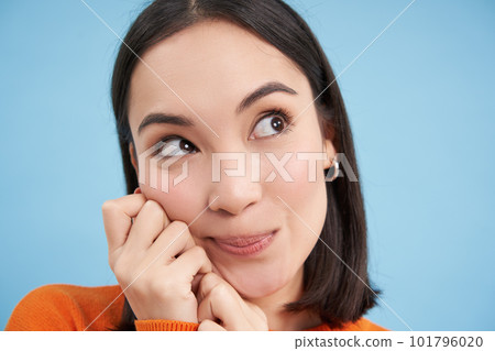 Beauty and wellbeing. Close up portrait of young happy asian woman, smiling and showing candid emotions, standing over blue background Beauty and wellbeing. Close up portrait of young happy asian woman, smiling and showing candid emotions, standing over blue background 101796020