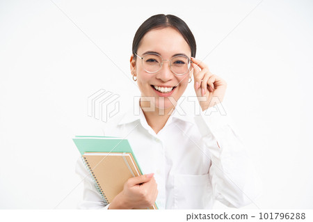 Smiling woman professional, asian female teacher with glasses, looking confident, standing over white background Smiling woman professional, asian female teacher with glasses, looking confident, standing over white background 101796288