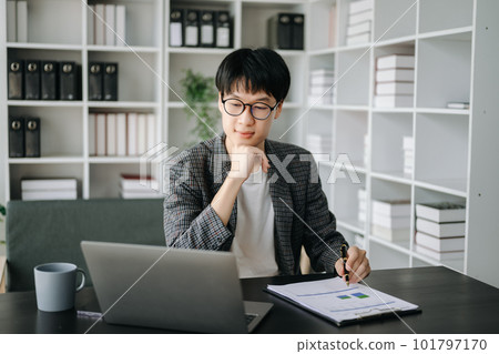 Young business man executive manager looking at laptop watching online webinar training or having virtual meeting video conference doing market research working in office... Young business man executive manager looking at laptop watching online webinar training or having virtual meeting video conference doing market research working in office... 101797170