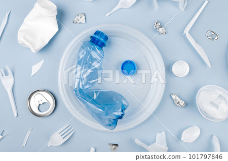 Bottle on the plate and other plastic waste on blue background Bottle on the plate and other plastic waste on blue background 101797846