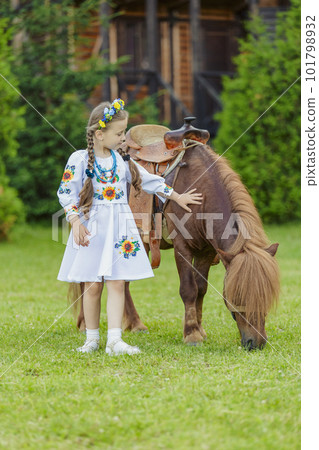 young girl in Ukrainian national dress strokes a pony young girl in Ukrainian national dress strokes a pony 101798932
