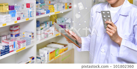 Pharmacist holding computer tablet Using for filling prescription in pharmacy drugstore Pharmacist holding computer tablet Using for filling prescription in pharmacy drugstore 101802360