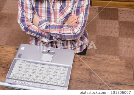 [Woman folding her arms while looking at a computer] 101806007