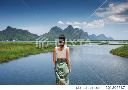 Young asian woman standing with limestone mountain range on wetland at Khao Sam Roi Yot 101806387