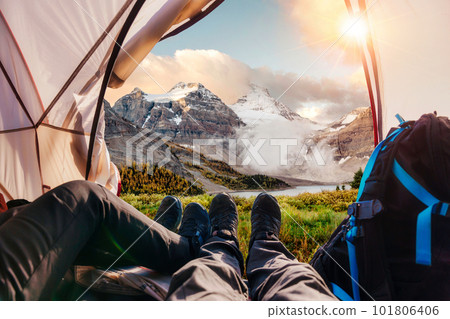 Legs of couple hiker relaxing inside a tent with Rocky Mountains view in national park 101806406