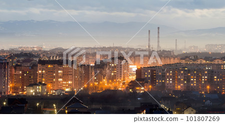Panorama of night aerial view of Ivano-Frankivsk city, Ukraine. Scene of modern night city with bright lights of tall buildings. Residential quaters and construction cranes in modern urban space. 101807269