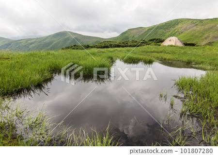 Panorama of cold foggy summer morning and tourist hikers tent in Carpathian mountains Panorama of cold foggy summer morning and tourist hikers tent in Carpathian mountains 101807280