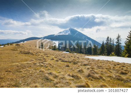 Mountain in windy sunny day with cloud overhead 101807427