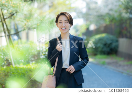 A woman in a suit walking outdoors A woman in a suit walking outdoors 101808463