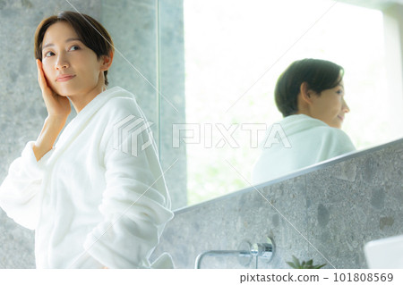 A woman doing skin care in a bathrobe A woman doing skin care in a bathrobe 101808569
