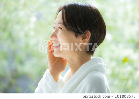 A woman doing skin care in a bathrobe A woman doing skin care in a bathrobe 101808575