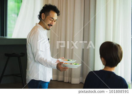 A middle-aged couple eating in the living room A middle-aged couple eating in the living room 101808591