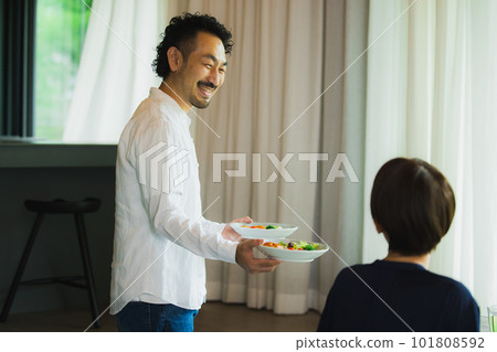 A middle-aged couple eating in the living room　 101808592