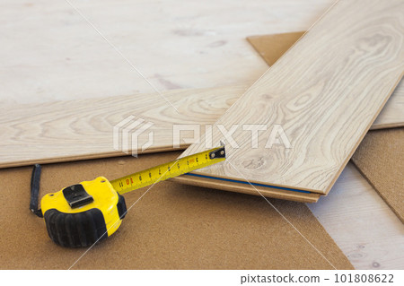 Measuring tape on laminate floor plank 101808622