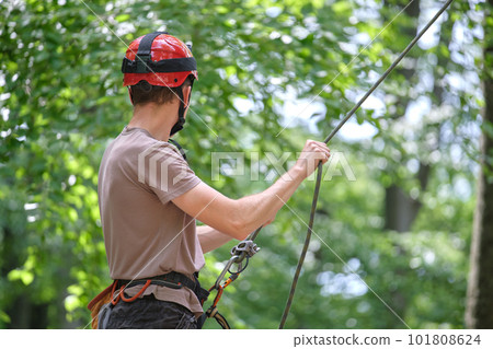 Man belays his partner climber with belaying device and rope. Climber's handsman holding equipment for rock mountaineering security. 101808624