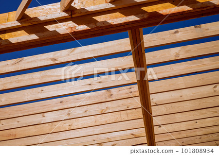 In newly built wooden home framing beam supports layout of joists. 101808934