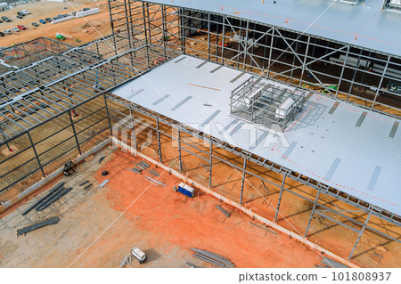 Steel frame truss framework construction of an industrial warehouse building in construction site Steel frame truss framework construction of an industrial warehouse building in construction site 101808937