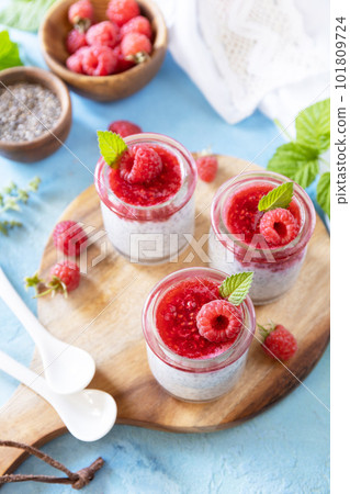 Chia seed pudding with raspberry and jam or smoothies with chia seeds on a stone table. Healthy breakfast. Copy space. Chia seed pudding with raspberry and jam or smoothies with chia seeds on a stone table. Healthy breakfast. Copy space. 101809724