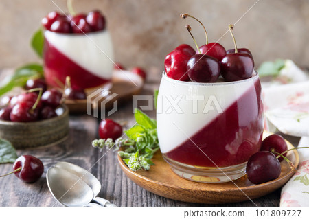 Panna cotta with sweet cherry jelly on a rustic table. Italian dessert, homemade cuisine. Copy space. 101809727