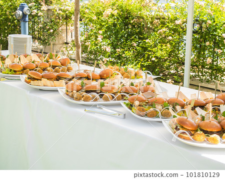Banquet table with snacks food on plates hamburger party dinner table - buffet table after wedding ceremony 101810129