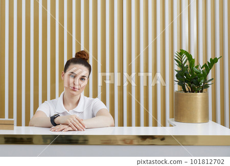 Female receptionist at reception desk in a modern office lobby 101812702