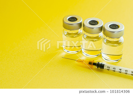 Image photo of a syringe and vial vitamin injection on a yellow background 101814306