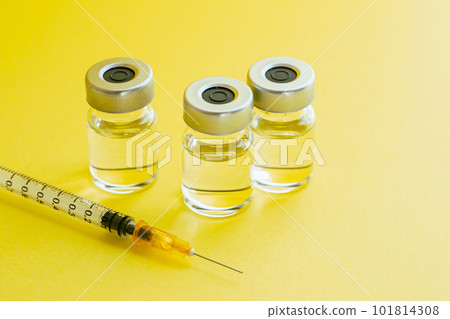 Image photo of a syringe and vial vitamin injection on a yellow background 101814308