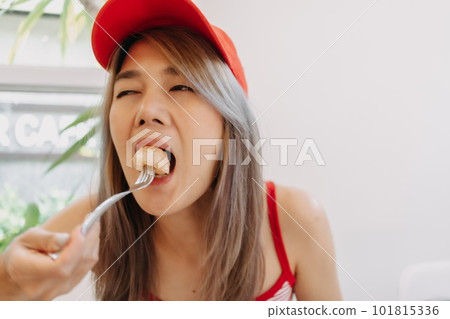 Funny cute girl in red eating fried dough dessert. Funny cute girl in red eating fried dough dessert. 101815336