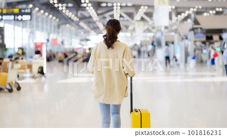 International airport terminal. Asian beautiful woman with luggage and walking in airport International airport terminal. Asian beautiful woman with luggage and walking in airport 101816231