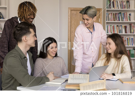 Five diverse teenage students engaged in teamwork gather in library Five diverse teenage students engaged in teamwork gather in library 101816819