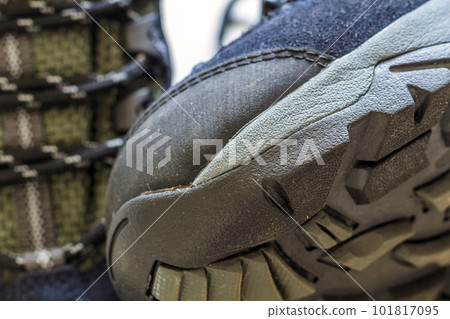 Detail shot of fragmrnt of new fashionable hiking mountain boot. Modern leather trekking footware. 101817095