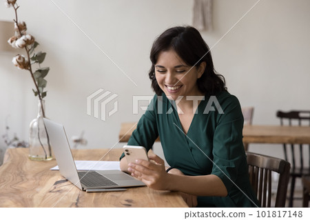 Happy Armenian businesswoman read sms on cellphone with good news Happy Armenian businesswoman read sms on cellphone with good news 101817148