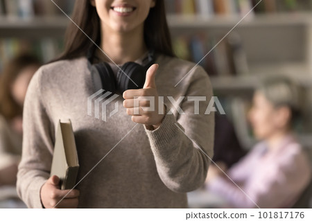 Girl poses in library showing thumbs up gesture, close up Girl poses in library showing thumbs up gesture, close up 101817176