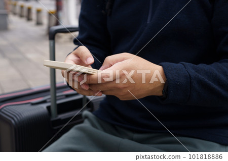 Man in downtown city street ordering taxi using smart phone app Booking taxi using application online on smart phone 101818886
