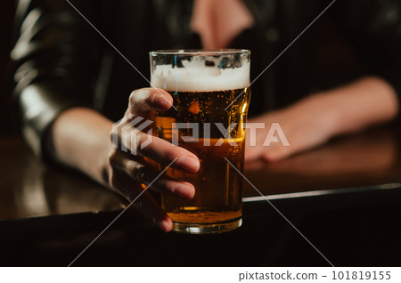 woman with big breasts holds a glass of beer lager with foam in her hand 101819155