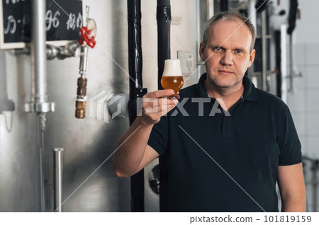brewer at a modern brewery with glass of beer 101819159