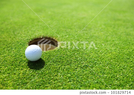 golf ball on lip of cup golf ball on lip of cup 101829714